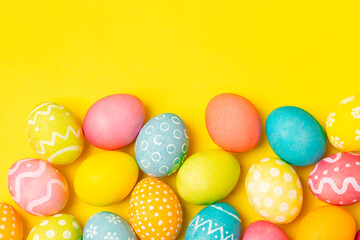 Easter eggs on a bright yellow background. Easter celebration concept. Colorful easter handmade decorated Easter eggs. Place for text. Copy space.