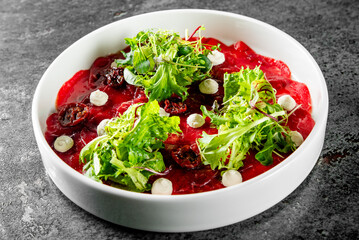 Beef carpaccio slice meat with salad on plate