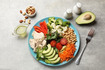 Balanced diet and healthy foods. Plate with different delicious products on grey table, flat lay