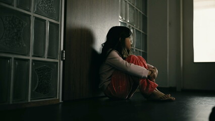 Lonely depressed child covering face in shame, little girl struggles with mental illness sitting in...