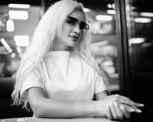 Fototapeta na wymiar Portrait of a young beautiful blonde girl indoors. Black and white photo.