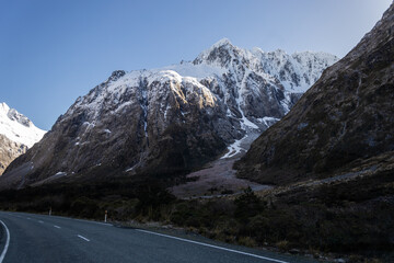 road to mild ford sound with snowy mountain in the background