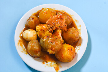 Siomay, traditional Indonesian food, steamed fish dumplings with peanut sauce. The background is blue