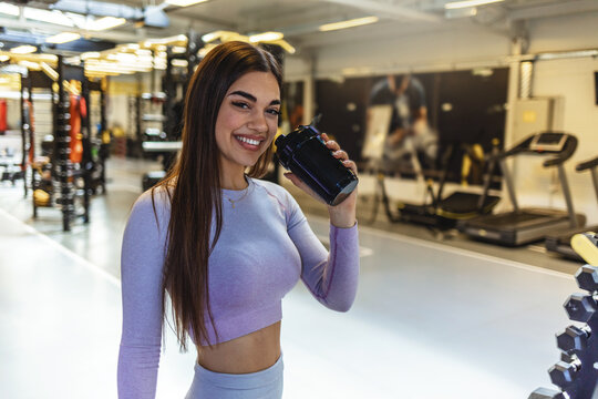 Woman, fitness and drinking water in relax at gym after workout, training or indoor exercise. Active or sporty female person with mineral drink on break for diet, natural nutrition or sustainability
