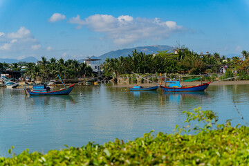 Fototapeta na wymiar Fishing boats on the river. The Kai River in Nha Trang in Vietnam. The urban landscape.