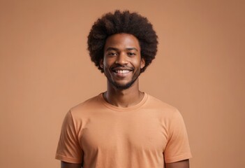 Fototapeta na wymiar A man with a warm smile and an afro hairstyle wears a simple t-shirt, standing against a plain background that highlights his relaxed demeanor.