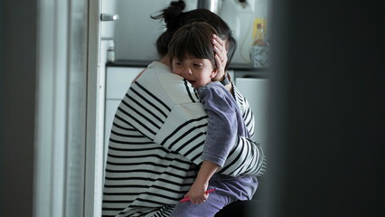 Tender mother consoles son in loving embrace in candid kitchen scene, loving mom with warm embrace...