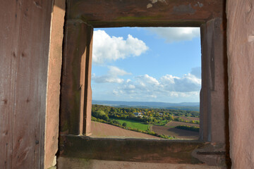 View through an old castle window on a  sky and green landscape