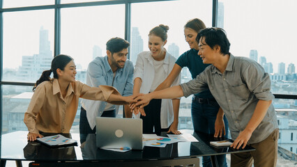 Group of multicultural businesspeople putting hands together at modern office. Happy cooperative...