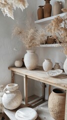 Rustic ceramic vases and bowls on wooden shelf with dried flowers