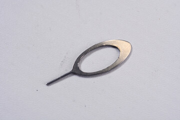 Close up of the "sim ejector" sim card opening tool inside a cell phone