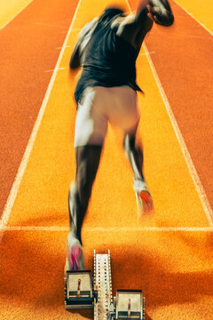 Un sprinter au d&eacute;part d'une course sur piste dans un stade