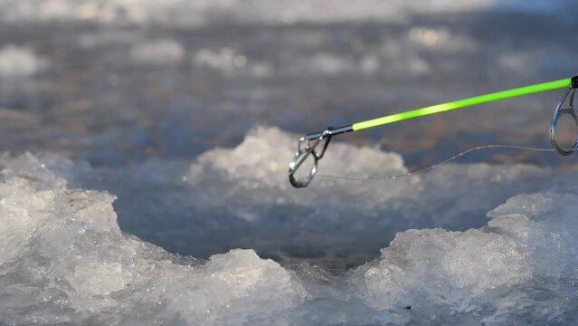 selective focus ice fishing rod tip and line ice hole 4k