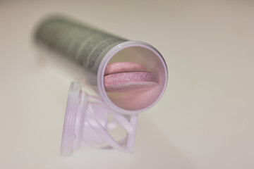 rosa Brausetabletten in einem Kunststoffröhrchen
