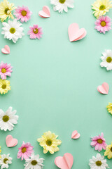 Petal symphony: spring's vibrant chorus. Top view vertical shot of white and pink flowers, heart-shaped paper decorations on teal background with space for messages