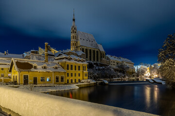 Winter view of Cesky Krumlov, picturesque houses under the castle with snow-covered roofs. Narrow streets and the Vltava river. Travel and Holiday. Christmas time. UNESCO World Heritage. Czechia