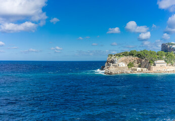 Fototapeta na wymiar Majestic Lighthouse Overlooking the Azure Waters of Port de Soller, Mallorca