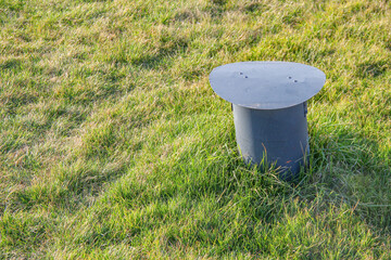Park infrastructure. Ventilation pipe in the park, coming out of the ground against the background...