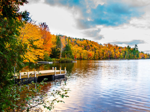 Lac-du-missionaire, Canada: Oct.10 2022: Morning fog on the lake of Lac-du-missionaire with colorful leaves in Quebec in a sunny autumn day