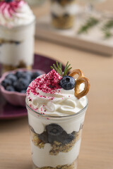 Whipped cream dessert with blueberries and cookies among flowers