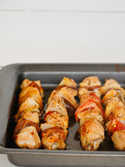 Close-up chicken skewers with vegetables in the oven with copy space.