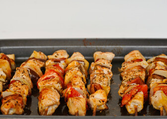 Close-up chicken skewers with vegetables in the oven with copy space.