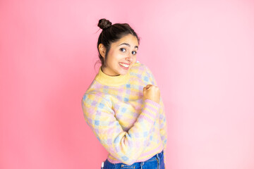 Obraz na płótnie Canvas Young beautiful woman wearing casual sweater over isolated pink background feeling happy, positive and successful, motivated when facing a challenge or celebrating good results