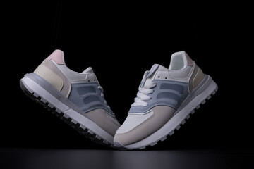 Light women's sneakers on a black background