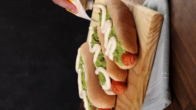 Chilean Typical Completo Food Hoy dog with tomato, avocado palta and mayonnaise Selective Focus. Vertical video.