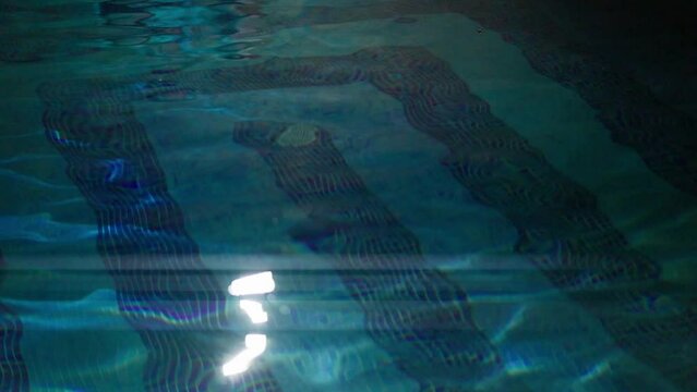 Slowmotion view of light being reflected in an swimming pool with anamorphic lens flare