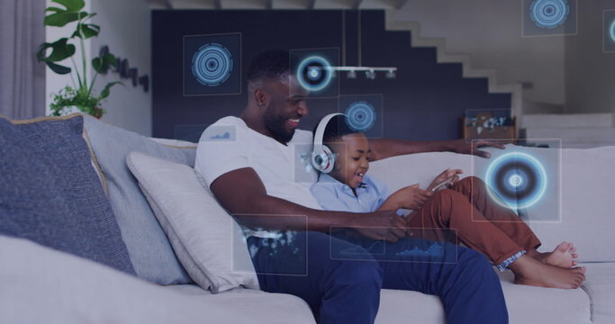 Image of diverse data over happy african american father and son using tablet