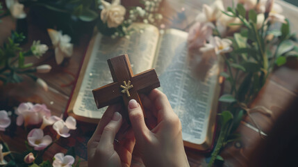 Christian woman holding a wooden cross in open Holy Bible on the church table.