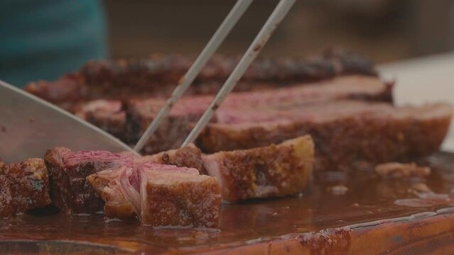 Chef cutting the roast beef, juicy and extremely soft Paraguayan barbecue. Chaco paraguayo, Slowmotion