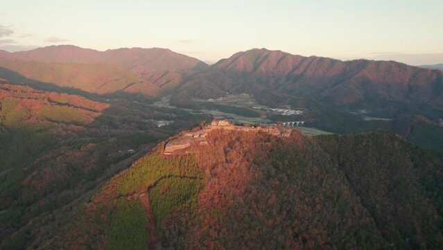 Aerial Drone Rotates Above Japanese Mountain Range in Hyogo Asago Landscape Sky is Clear around Takeda Castle Ruins