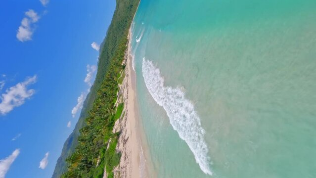 Crazy drone flying over turquoise ocean waters of Playa Rincon beach in Dominican Republic. Aerial FPV and vertical format