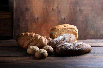 Lots of different breads on a dark wooden background
