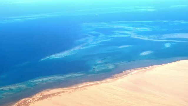 Line between desert and ocean water, high altitude aerial view