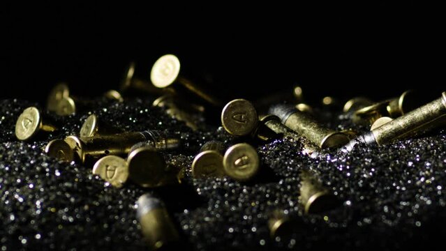 .22 Long Rifle Cartridges In Heap Of Gunpowder Against Black Backdrop. closeup shot
