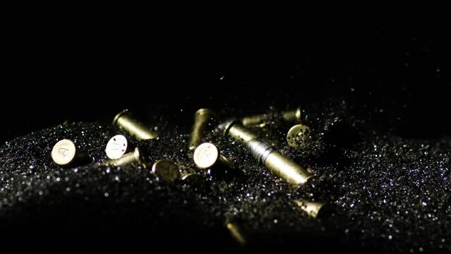 .22 Long Rifle Bullets Falling Into Bullet Grains. slow motion, zoom-in shot