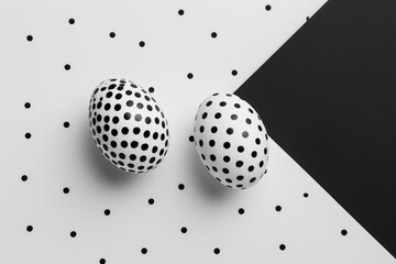 Two polka dotted Easter eggs juxtaposed on a dual black and white background with a dot pattern, illustrating a minimalist yet bold design. For modern Easter themes and graphic visual concepts