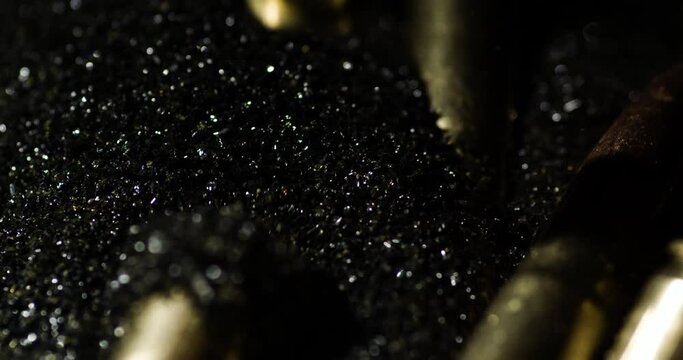 Detail macro shot of bullets .300 AAC Blackout falling on gunpowder dust, slowmo