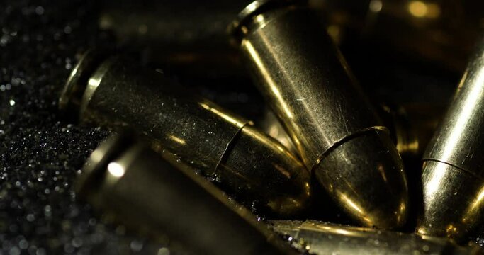 9&times;19mm Parabellum bullets sitting on gunpowder dust pile, macro detail closeup