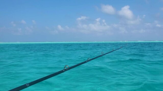 Man's Hand Holding a Fishing Rod While Standing On A Sailing Boat Caribbean Sea
