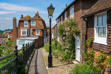 An antique street lamp by the footpath that leads past the brick townhouses