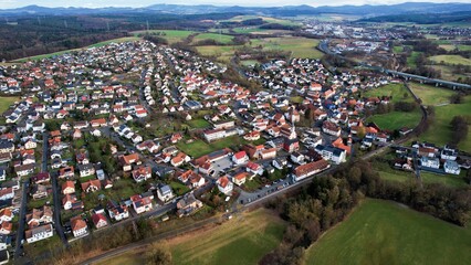 Fototapeta na wymiar Aerial of the village Eichenzell in Germany on a cloudy day in late winter