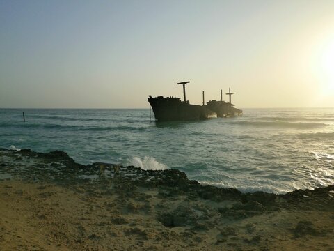 an old boat is floating in the ocean at sunset time kish island