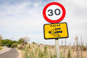 speed limit sign and radar warning in a country road - 744236965
