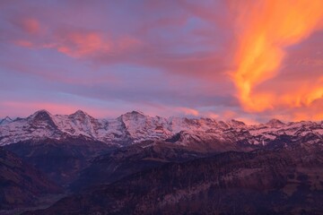 Majestic mountain range illuminated by the soft pink light of the setting sun.