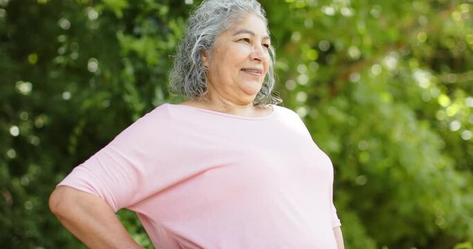 Senior biracial woman stands confidently outdoors