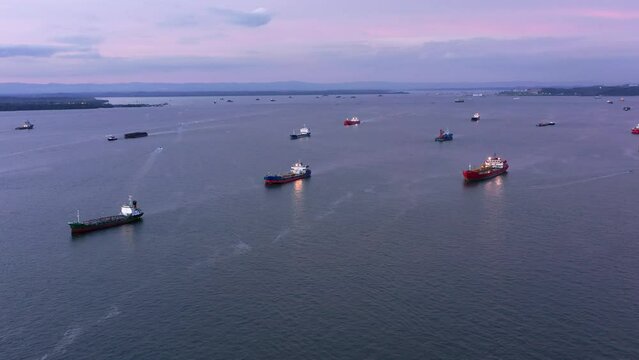 Coast full of Oil and LPG Tankers in the evening - Aerial shot - Port of Balikpapan city - Indonesia